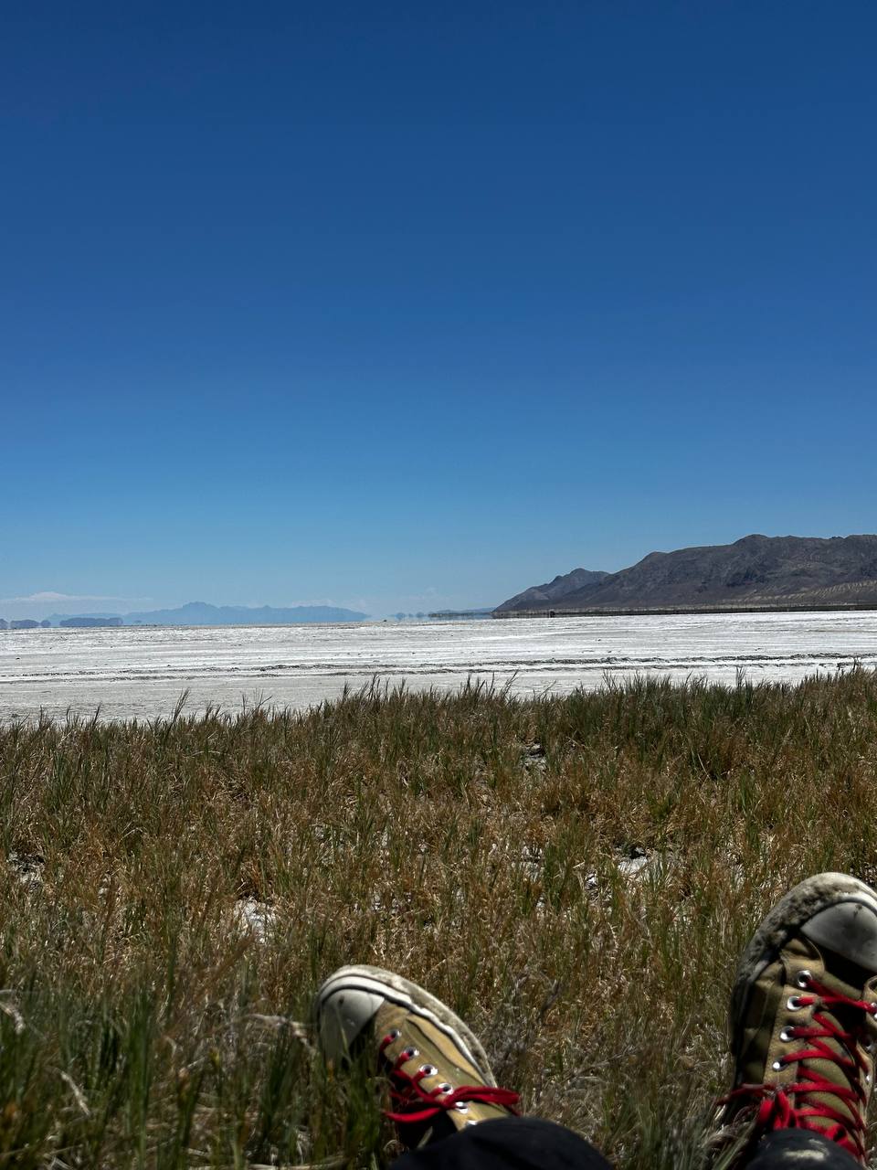 Field personnel resting with boots visible at the edge of the playa